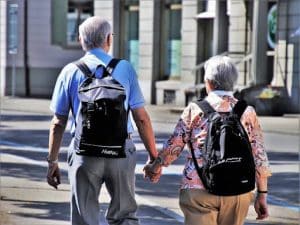 An older couple is shown walking down the street together