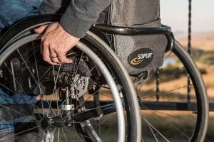 A man rolls the wheels of his wheelchair